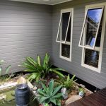 Courtyard with plants, pond, and grey painted exterior walls.