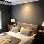 Bedroom with grey walls, timber side tables, and lamps.