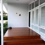 House exterior with white walls, large windows, and front steps.