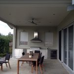 Outdoor patio dining area with BBQ and ceiling fan