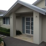 Modern home entrance with double glass doors and columns