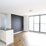 Modern open-plan kitchen and living area with timber floors and large glass doors.