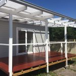 Timber deck with white pergola attached to a modern house.