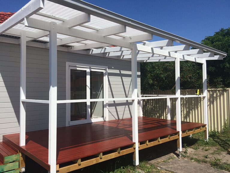 Timber deck with white pergola attached to a modern house.