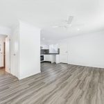 Spacious living area with timber floors and white walls.