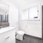 Contemporary bathroom with vanity, toilet, and glass shower.