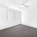 Empty bedroom with mirrored sliding wardrobe doors