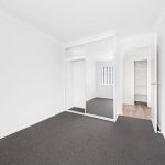 Empty bedroom with mirrored sliding wardrobe doors